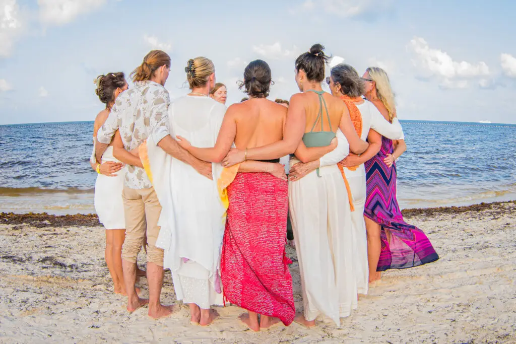 People standing in a circle on the beach